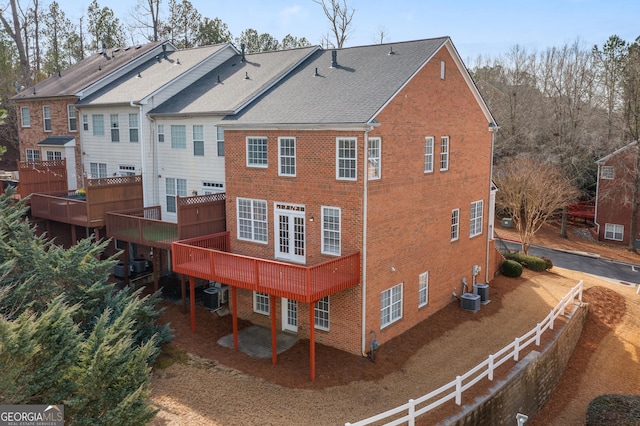 rear view of property featuring cooling unit, french doors, and a deck