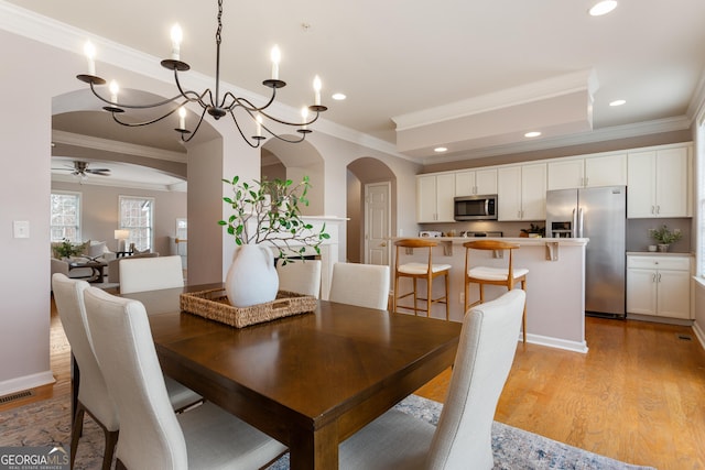 dining room with crown molding, light hardwood / wood-style flooring, and ceiling fan