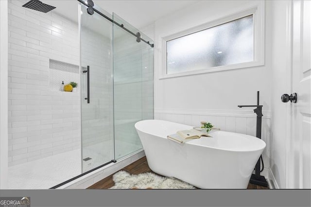 bathroom with hardwood / wood-style flooring and separate shower and tub