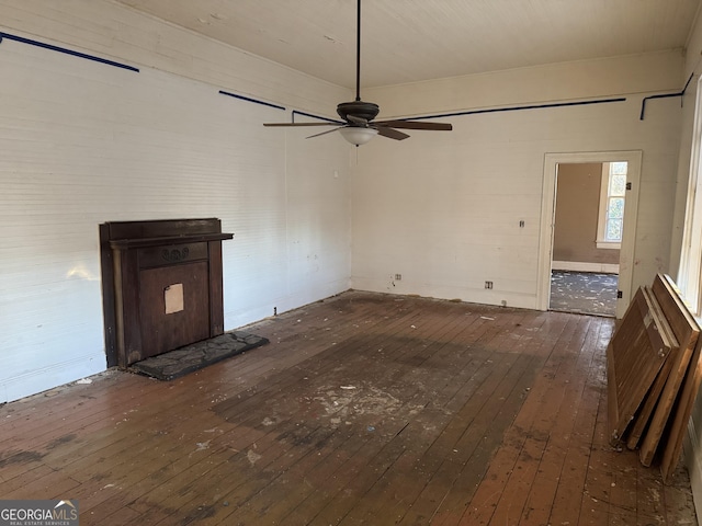 unfurnished living room with dark wood-type flooring and ceiling fan