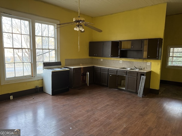 kitchen featuring dark wood-type flooring, dark brown cabinetry, range with electric stovetop, ceiling fan, and backsplash