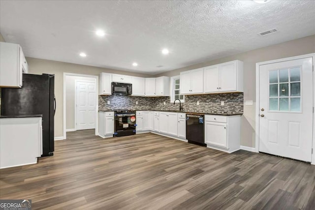 kitchen featuring sink, white cabinetry, black appliances, a textured ceiling, and dark hardwood / wood-style flooring