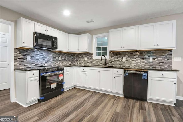 kitchen with sink, black appliances, dark hardwood / wood-style flooring, white cabinets, and backsplash