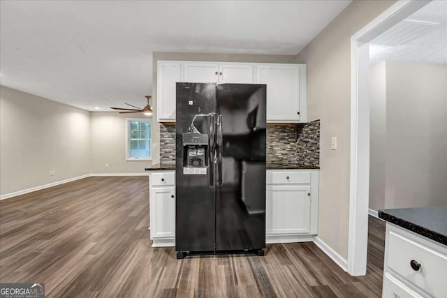 kitchen with dark hardwood / wood-style floors, backsplash, white cabinets, and black fridge with ice dispenser