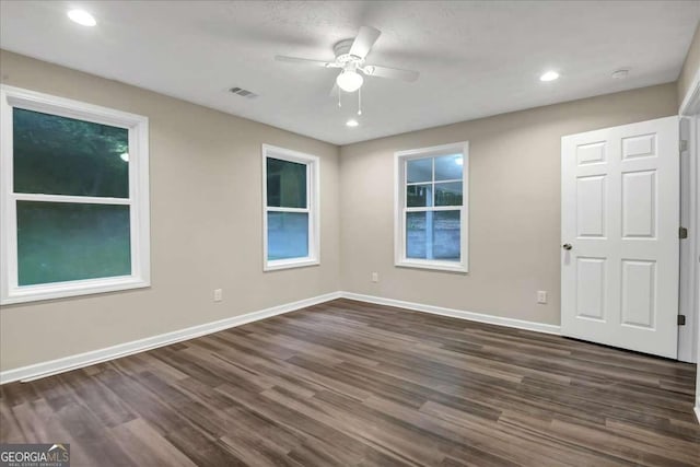 spare room with dark hardwood / wood-style flooring and ceiling fan