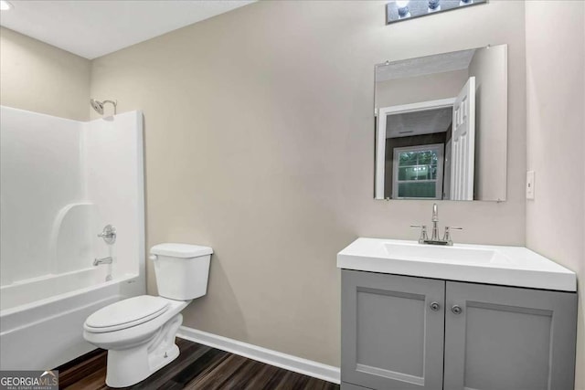 full bathroom featuring hardwood / wood-style flooring, shower / washtub combination, toilet, and vanity