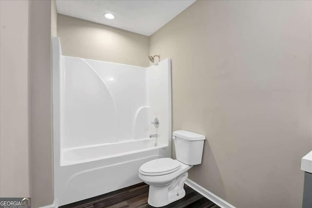 bathroom featuring wood-type flooring,  shower combination, and toilet