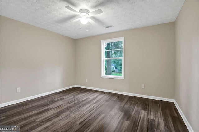 empty room with ceiling fan, dark hardwood / wood-style floors, and a textured ceiling