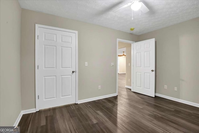 unfurnished bedroom featuring a textured ceiling, dark hardwood / wood-style floors, and ceiling fan