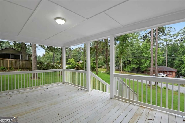 wooden terrace featuring a lawn