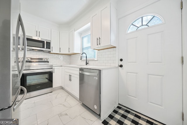 kitchen with white cabinetry, sink, decorative backsplash, stainless steel appliances, and crown molding