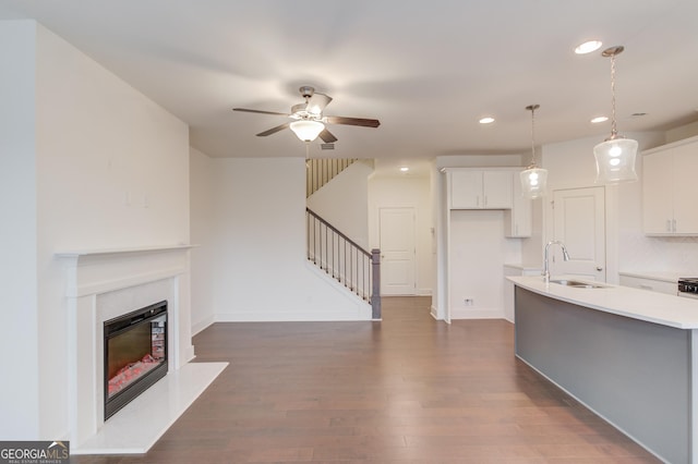 kitchen featuring decorative light fixtures, tasteful backsplash, white cabinetry, sink, and ceiling fan