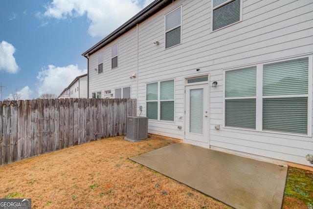 rear view of house with a patio, a yard, and central AC