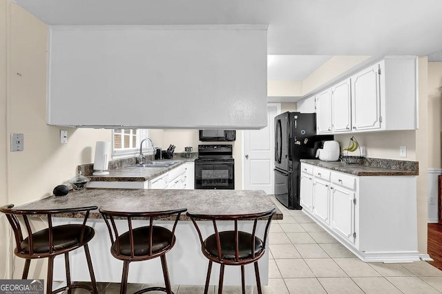 kitchen with white cabinetry, sink, light tile patterned floors, and black appliances