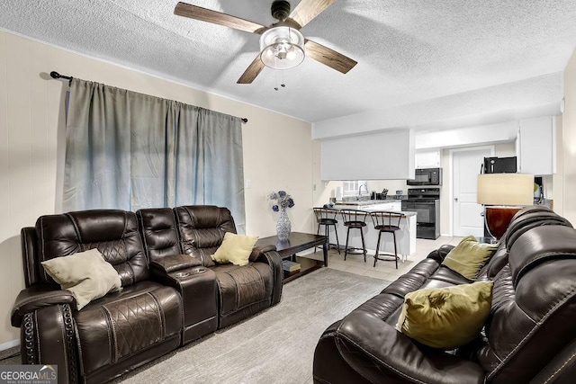 tiled living room featuring ceiling fan and a textured ceiling