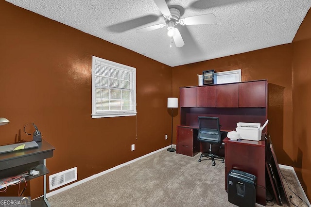 office area featuring ceiling fan, light colored carpet, and a textured ceiling