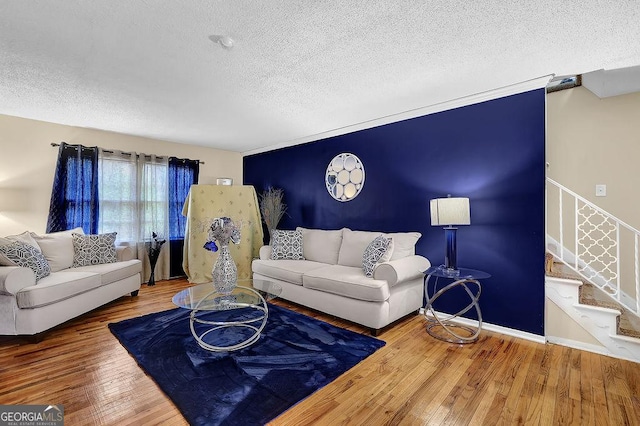 living room featuring wood-type flooring and a textured ceiling