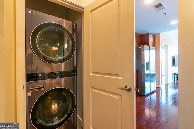 washroom featuring dark hardwood / wood-style flooring and stacked washer and clothes dryer