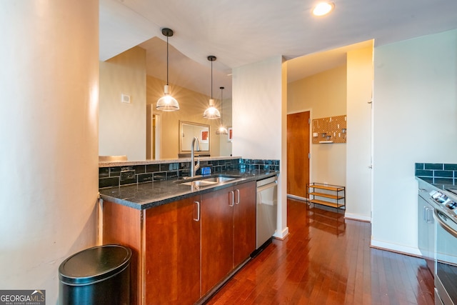 kitchen featuring sink, appliances with stainless steel finishes, hanging light fixtures, dark hardwood / wood-style floors, and tasteful backsplash