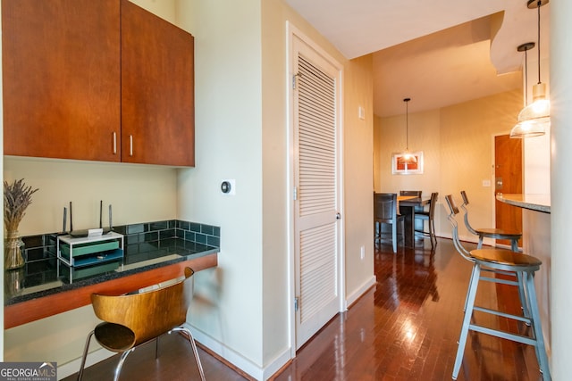 kitchen with dark hardwood / wood-style flooring and hanging light fixtures