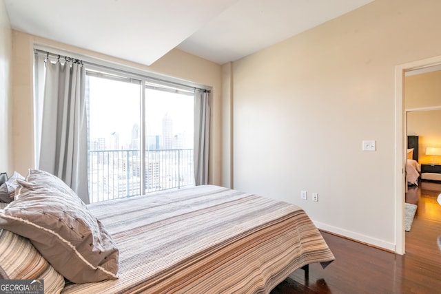 bedroom featuring dark wood-type flooring and access to outside