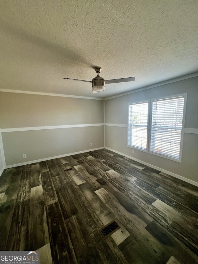 empty room featuring dark wood-type flooring, a textured ceiling, and ceiling fan