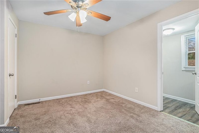 carpeted spare room featuring ceiling fan