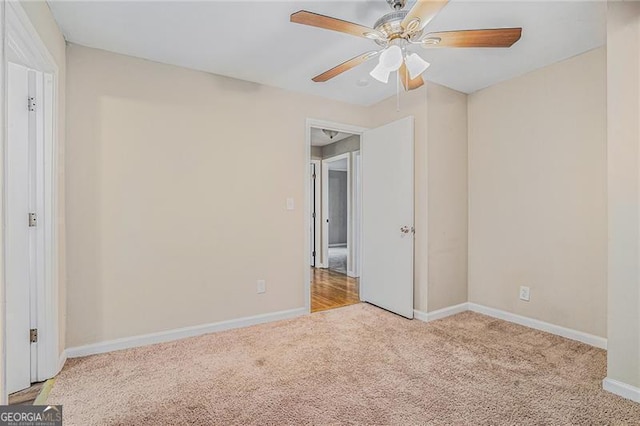 carpeted spare room featuring ceiling fan