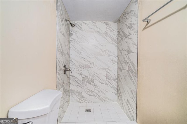 bathroom with toilet and a tile shower