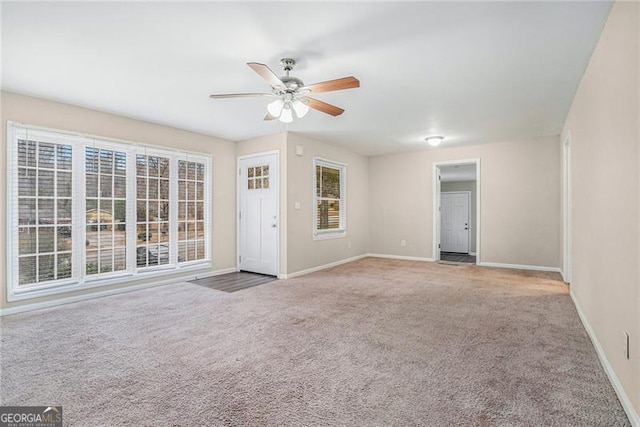 interior space featuring a wealth of natural light, light colored carpet, and ceiling fan