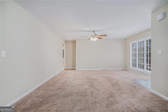 carpeted spare room with ceiling fan