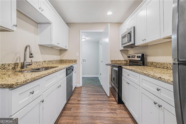 kitchen featuring light stone counters, sink, white cabinets, and appliances with stainless steel finishes