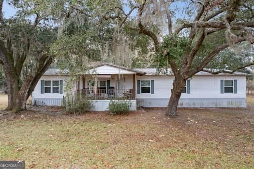 ranch-style house with a front lawn and covered porch