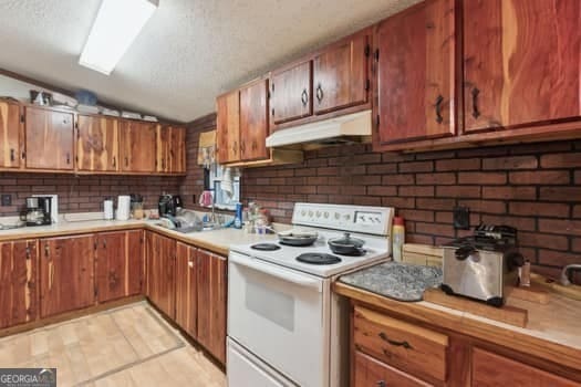 kitchen with white range with electric cooktop, lofted ceiling, and sink