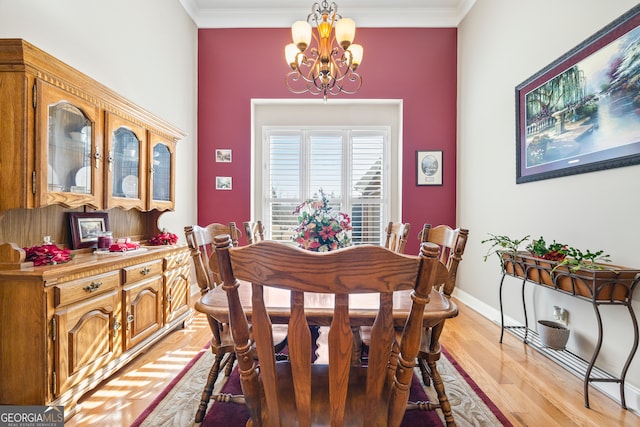 dining area with ornamental molding, a chandelier, and light hardwood / wood-style flooring