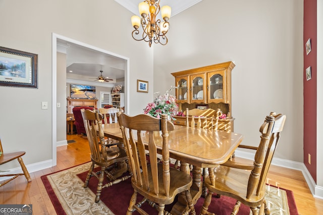 dining space featuring crown molding, ceiling fan with notable chandelier, and light hardwood / wood-style flooring