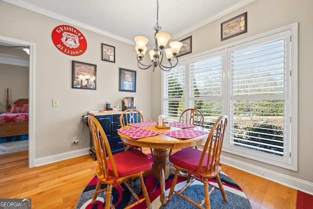 dining room featuring an inviting chandelier, ornamental molding, and light hardwood / wood-style flooring