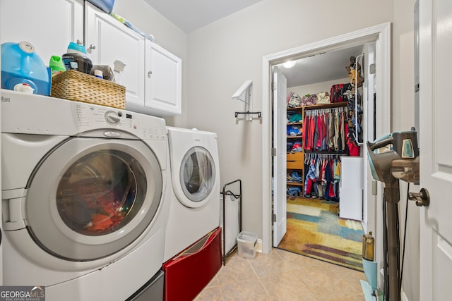 laundry area with washing machine and dryer, cabinets, and light tile patterned flooring