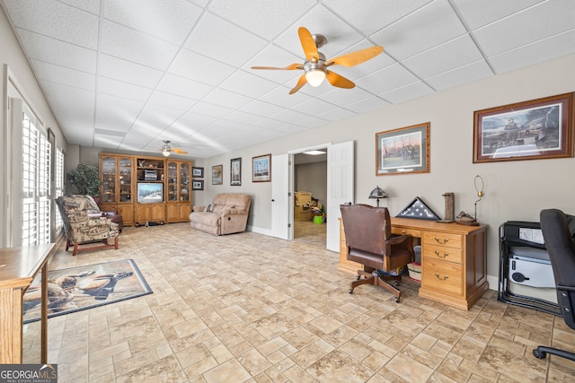 home office with a paneled ceiling and ceiling fan