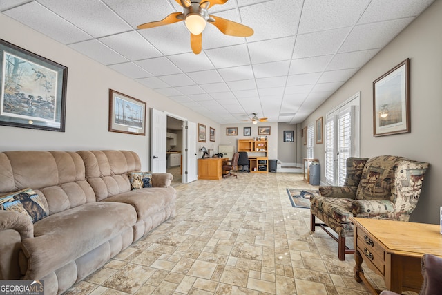 living room featuring a drop ceiling and ceiling fan