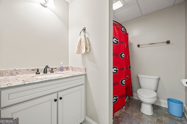 bathroom with a shower with curtain, vanity, a paneled ceiling, and toilet