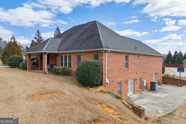 rear view of house featuring central AC unit and a patio area