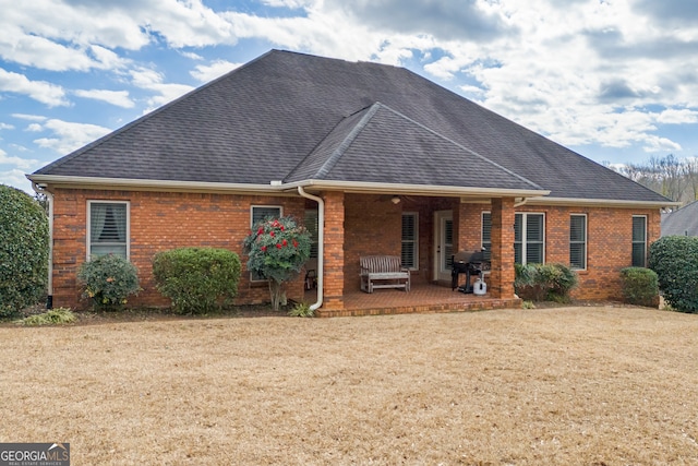 rear view of house with a yard and a patio