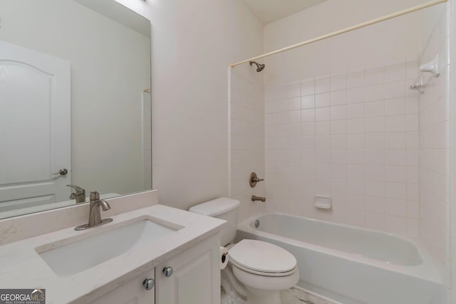 full bathroom featuring tiled shower / bath, vanity, and toilet