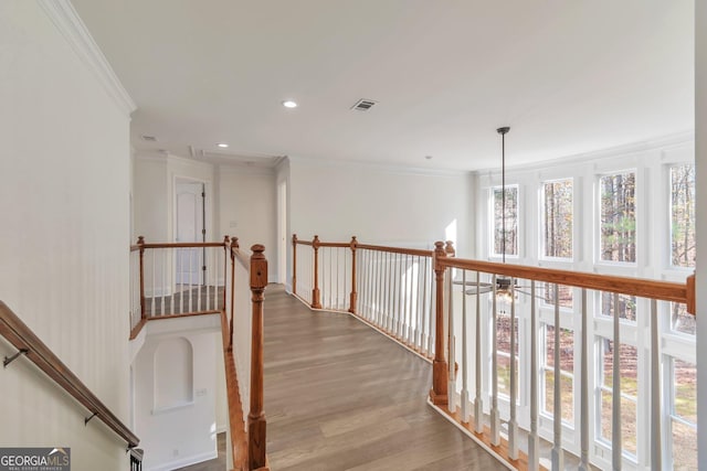 hallway featuring ornamental molding and light hardwood / wood-style flooring