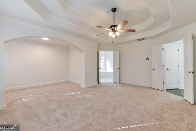 carpeted empty room with ornamental molding, a raised ceiling, and ceiling fan