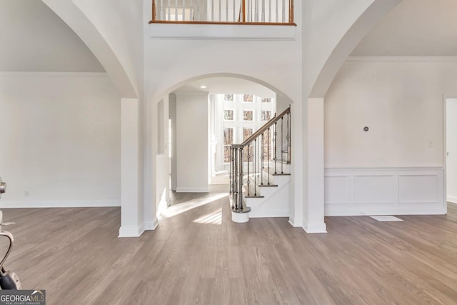 foyer entrance featuring ornamental molding and light hardwood / wood-style floors