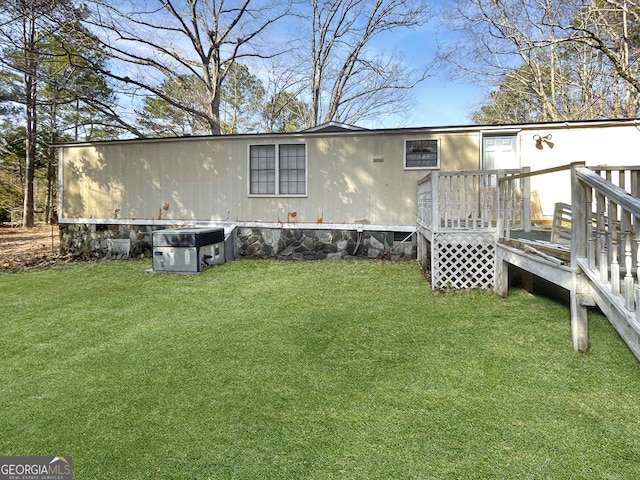 rear view of property with a wooden deck and a yard