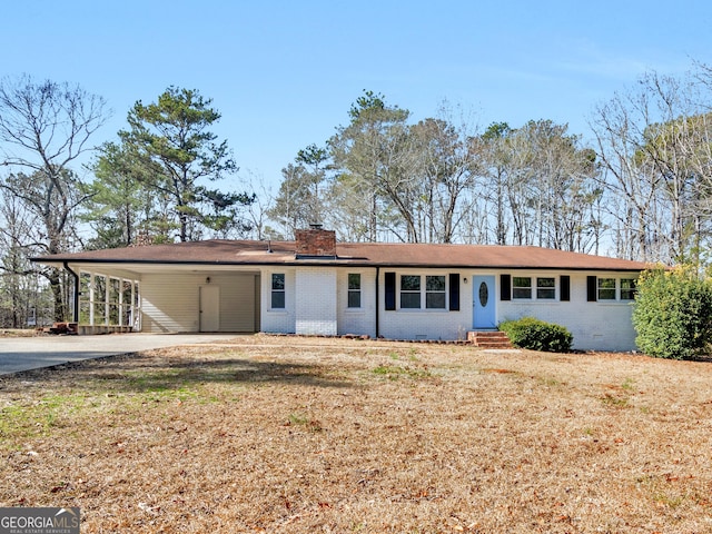 ranch-style house featuring a carport and a front lawn