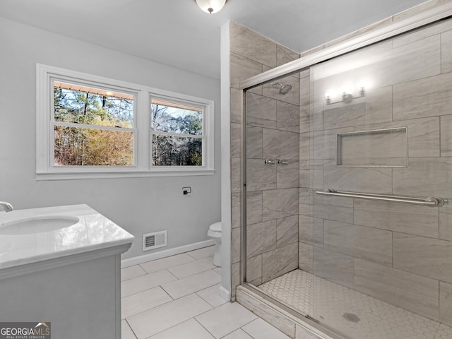 bathroom featuring vanity, tile patterned flooring, toilet, and walk in shower